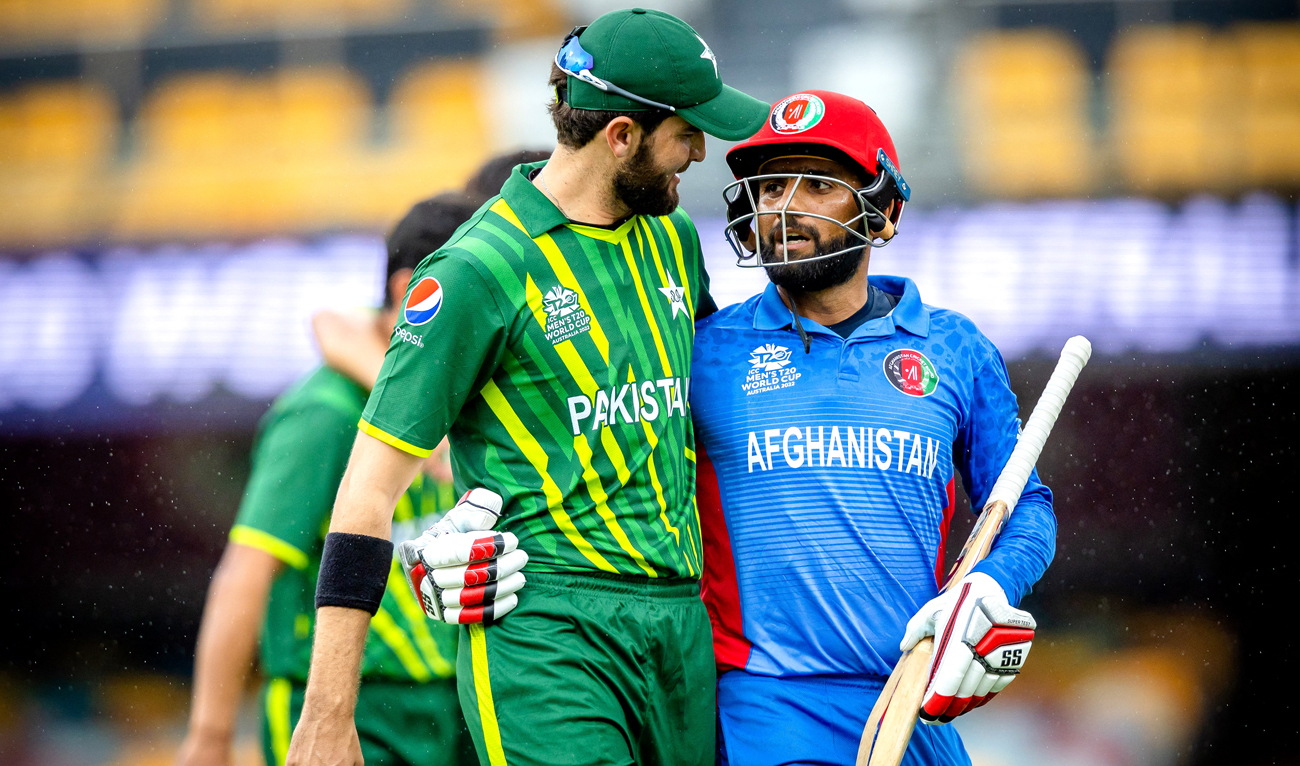 Pakistan's Shaheen Shah Afridi (L) embraces Usman Ghani (R) as they both walk off together during the ICC men's Twenty20 World Cup 2022 cricket warm-up match between Afghanistan and Pakistan at the Gabba in Brisbane on October 19, 2022. (AFP)