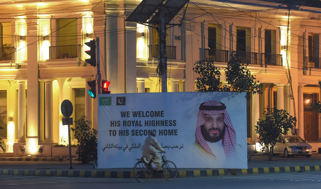 A Pakistani man rides past a billboard displaying a portrait of Saudi Arabian Crown Prince Mohammed bin Salman in Lahore on February 16, 2019. (AFP/File)