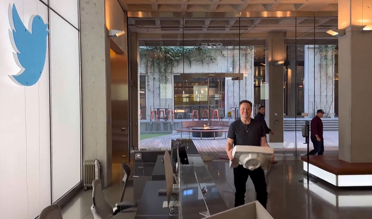 This video grab taken from a video posted on the Twitter account of billionaire Tesla chief Elon Musk on October 26, 2022 shows himself carrying a sink as he enters the Twitter headquarters in San Francisco. (AFP)