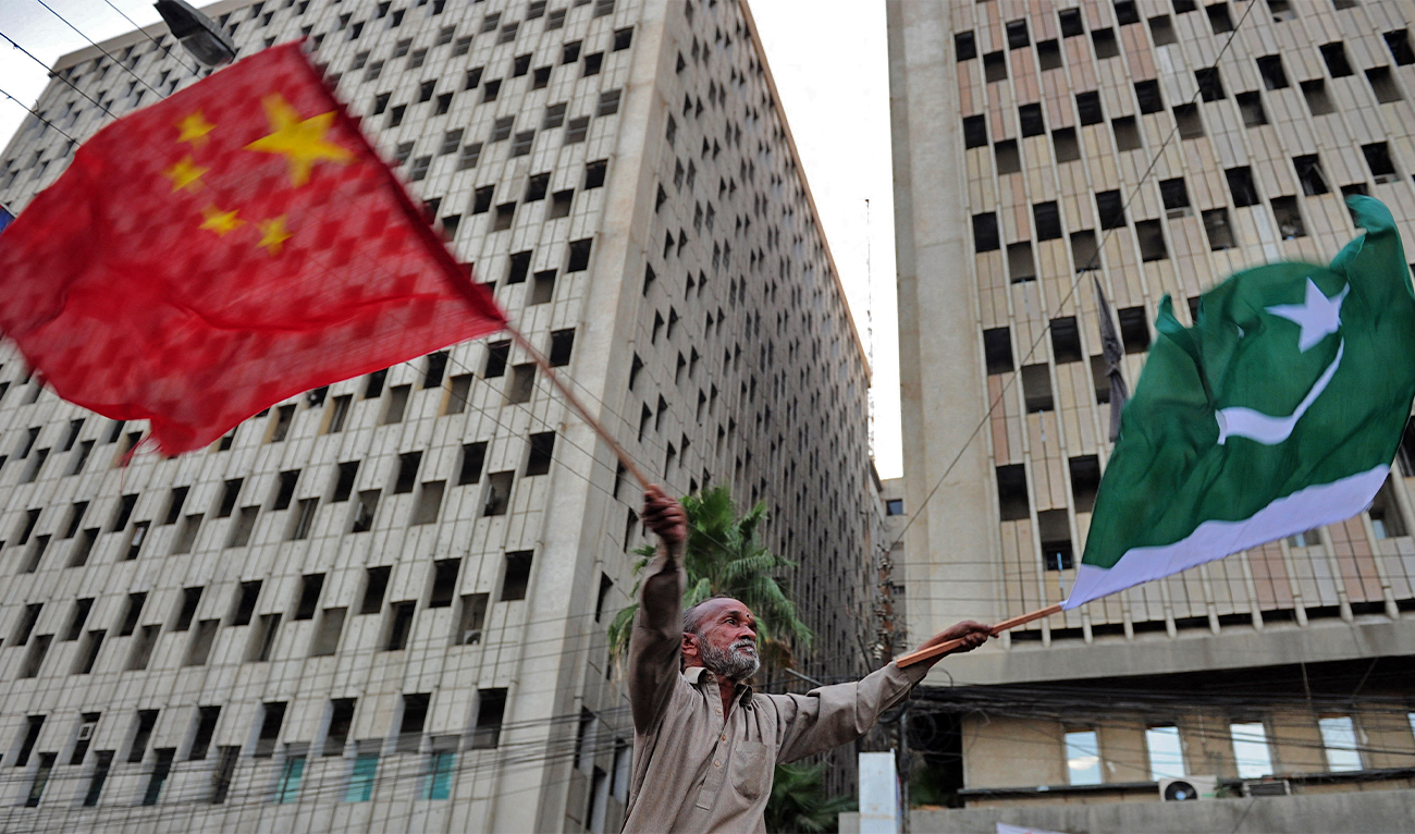 A Pakistani man waves Pakistani and Chinese national flags on a street of Karachi on December 19, 2010. (AFP/File)