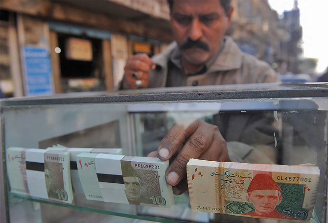 A vendor arranges 10 and 20-rupee Pakistani bank notes in a display shelf at a commercial area in Karachi, Pakistan, on December 14, 2011. (AFP/File)