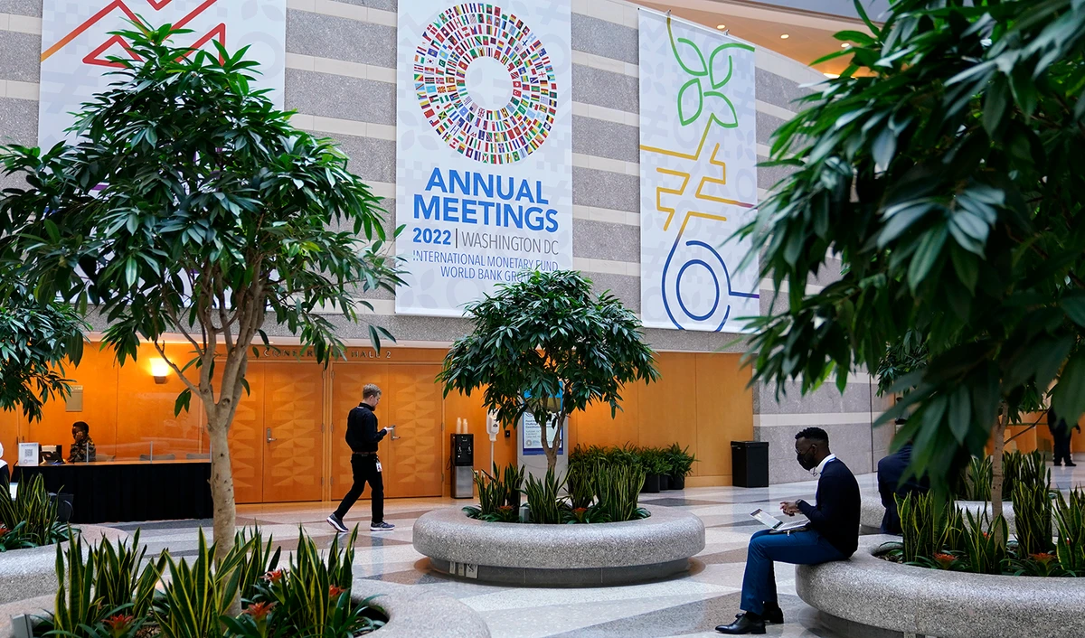 Attendees gather inside an atrium at the 2022 Annual Meetings of the International Monetary Fund and the World Bank Group, Monday, Oct. 10, 2022, in Washington. (AP)