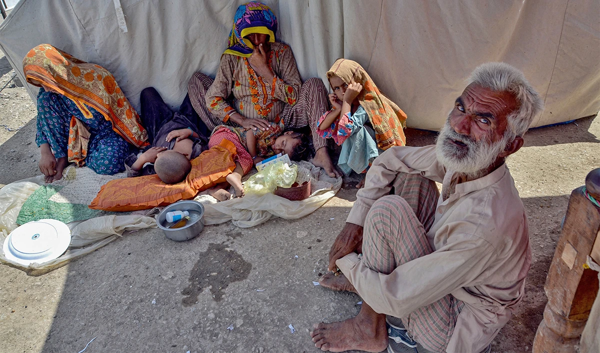 nternally displaced flood-affected people sit next to their tent as they take refuge at a makeshift camp at Dera Allah Yar in Jaffarabad district of Balochistan province on September 22, 2022. (AFP)