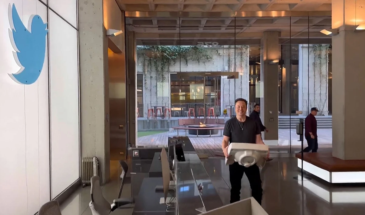 This video grab taken from a video posted on the Twitter account of billionaire Tesla chief Elon Musk on October 26, 2022 shows himself carrying a sink as he enters the Twitter headquarters in San Francisco. (AFP)