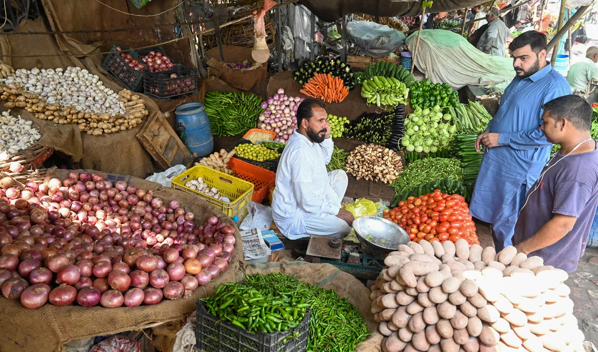 People buy vegetables at a local market in Lahore on August 29, 2022. (AFP/File)