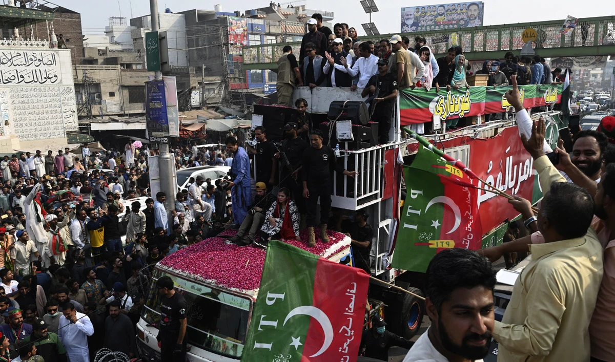 Pakistan's former prime minister Imran Khan (C top) gestures to his supporters during an anti-government march towards Islamabad city, demanding early elections, in Muridke district, about 29 km from Lahore on October 30, 2022. (AFP)