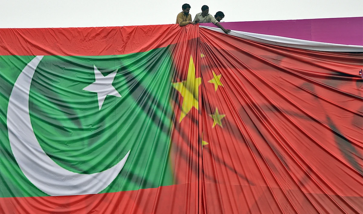 Pakistani labourers arrange a billboard featuring the Chinese and Pakistani national flags in Islamabad, Pakistan, on April 18, 2015. (AFP/File)