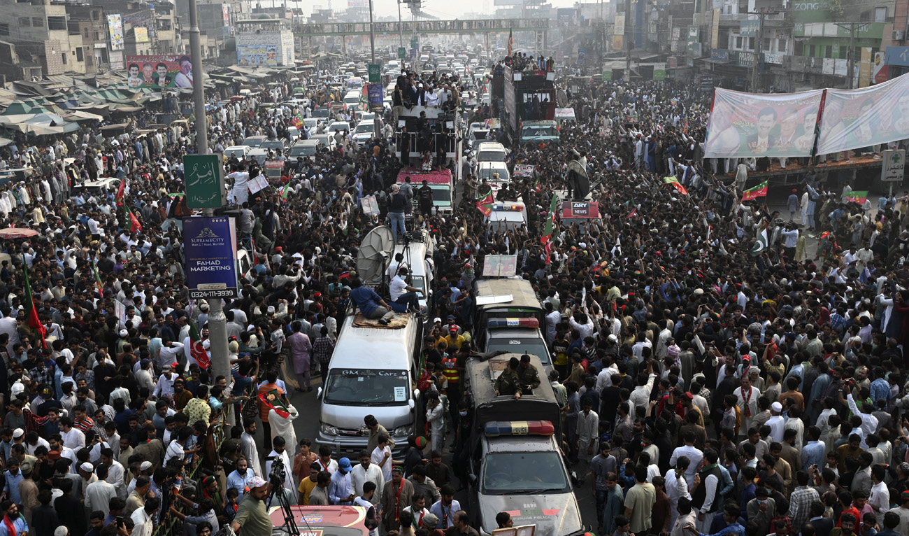 Pakistan's former prime minister Imran Khan (C, on truck) along with his party leaders take part in an anti-government march towards Islamabad city, demanding early elections, in Muridke district, about 29 km from Lahore on October 30, 2022. (AFP)