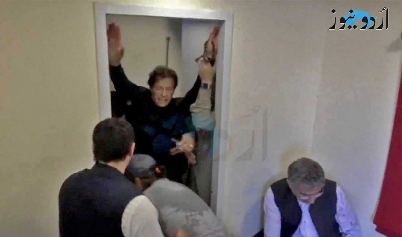 Former Pakistani Prime Minister Imran Khan is helped after he was shot in the shin in Wazirabad, Pakistan November 3, 2022 in this still image obtained from video. (Urdu News)