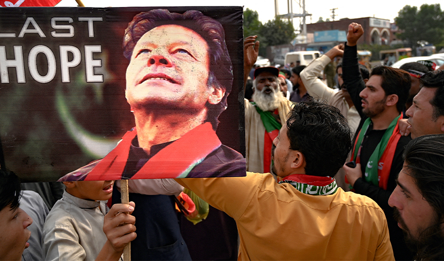 Supporters of former Pakistani prime minister Imran Khan, take part in a protest near the container truck a day after the assassination attempt on Khan, at the cordoned-off site of a gun attack in Wazirabad on November 4, 2022. (AFP)