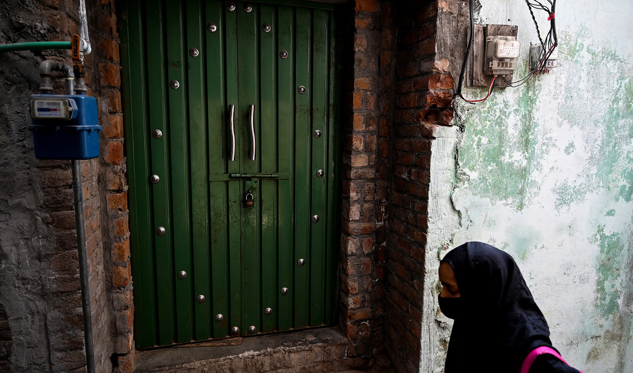 A child walks past a locked house of an attacker, who made an assassination attempt on former Pakistani prime minister Imran Khan, on his container truck a day after at Sodhra in Gujranwala district on November 4, 2022. (Photo courtesy: AFP)