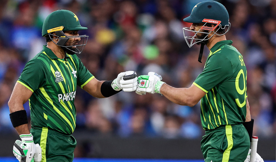 Pakistan's Iftikhar Ahmed (L) and Shan Masood bump gloves during the ICC men's Twenty20 World Cup 2022 cricket match between India and Pakistan at Melbourne Cricket Ground (MCG) in Melbourne on October 23, 2022. (AFP)