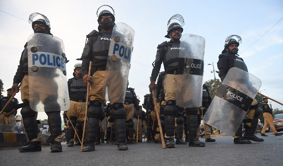Police stand guard during a protest by supporters of former Pakistan prime minister Imran Khan against the assassination attempt on him in Karachi on November 5, 2022. (AFP)