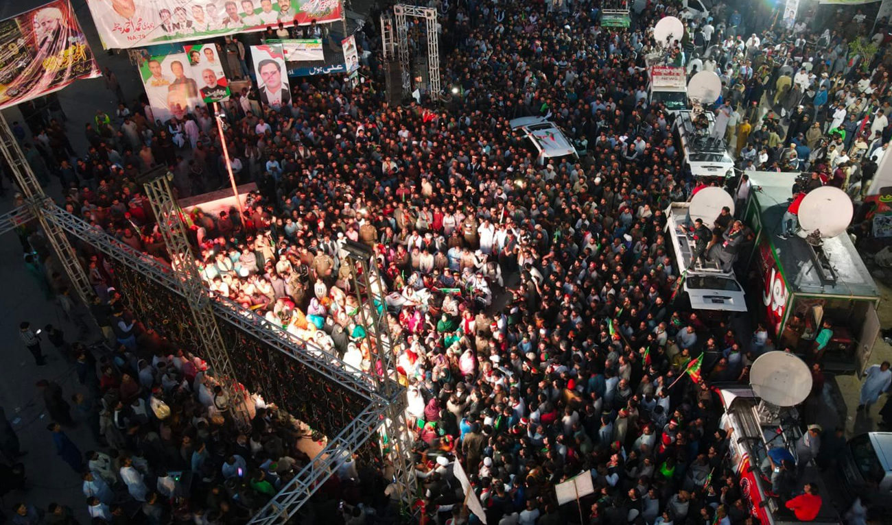 Pakistan Tehreek-e-Insaf party supporters watch on Chairman Imran Khan's address on screen in Wazirabad city on November 10, 2022. (Photo courtesy: Twitter/PTI)