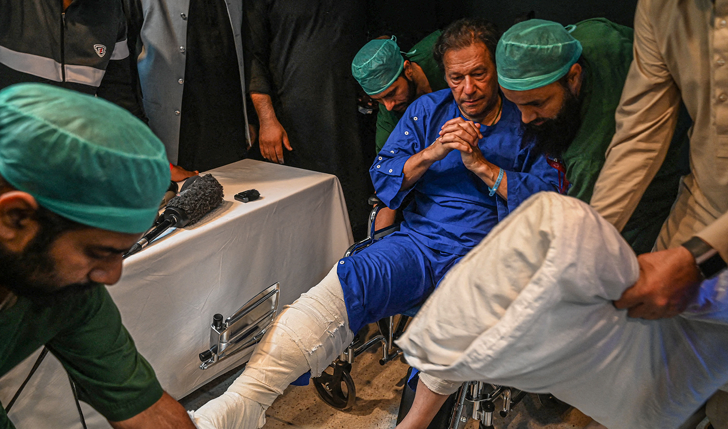 Pakistani paramedics move Pakistan's former prime minister Imran Khan as he sits in a wheelchair, after speaking to media representatives at a hospital in Lahore on November 4, 2022, a day after an assassination attempt on him near Wazirabad. (AFP/File)