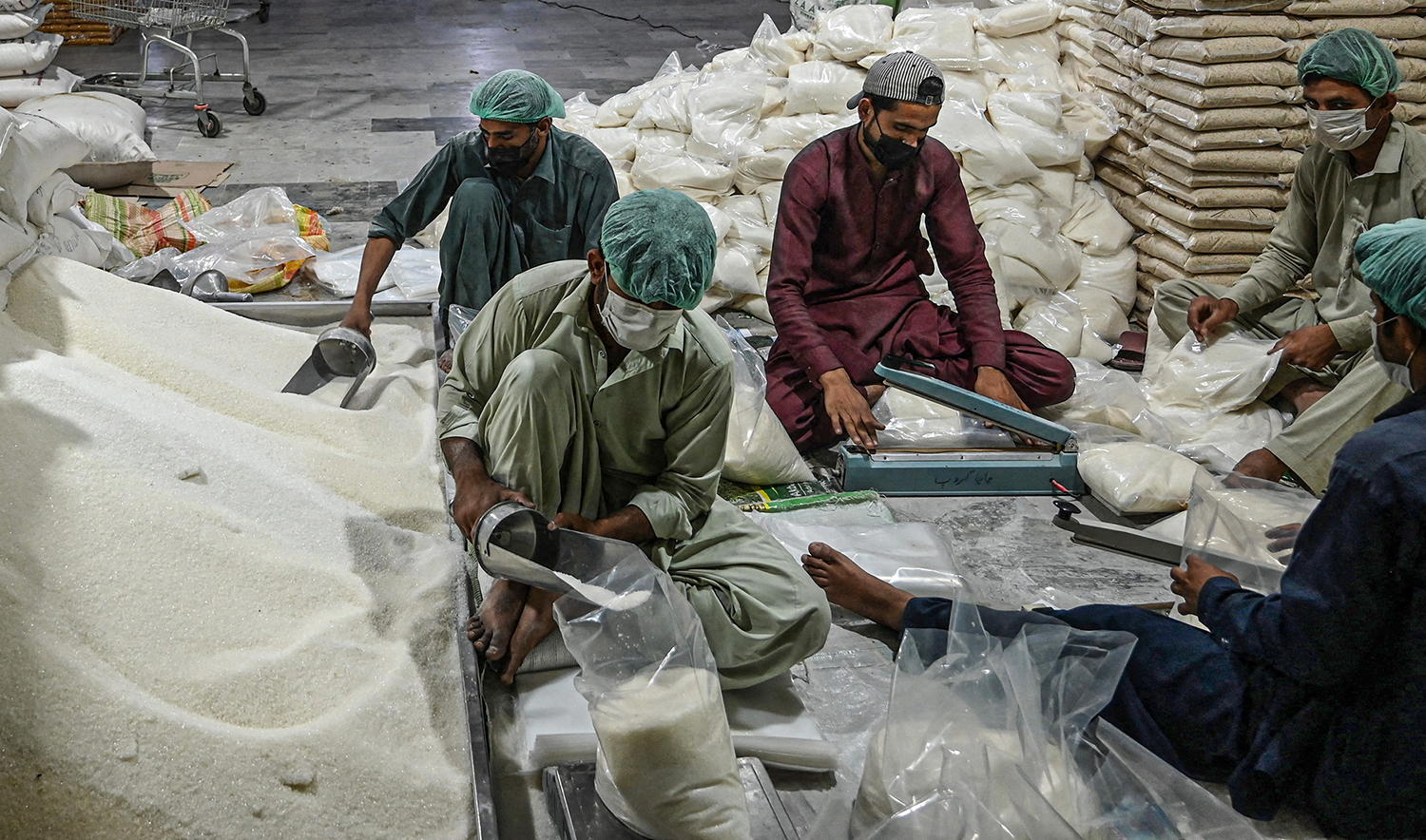 Workers of the Al-Khidmat Foundation, a charity organization, prepare sugar bags to be distributed to people in need, ahead of the Holy month of Ramadan at a warehouse in Islamabad, Pakistan, on April 11, 2021. (AFP/File)