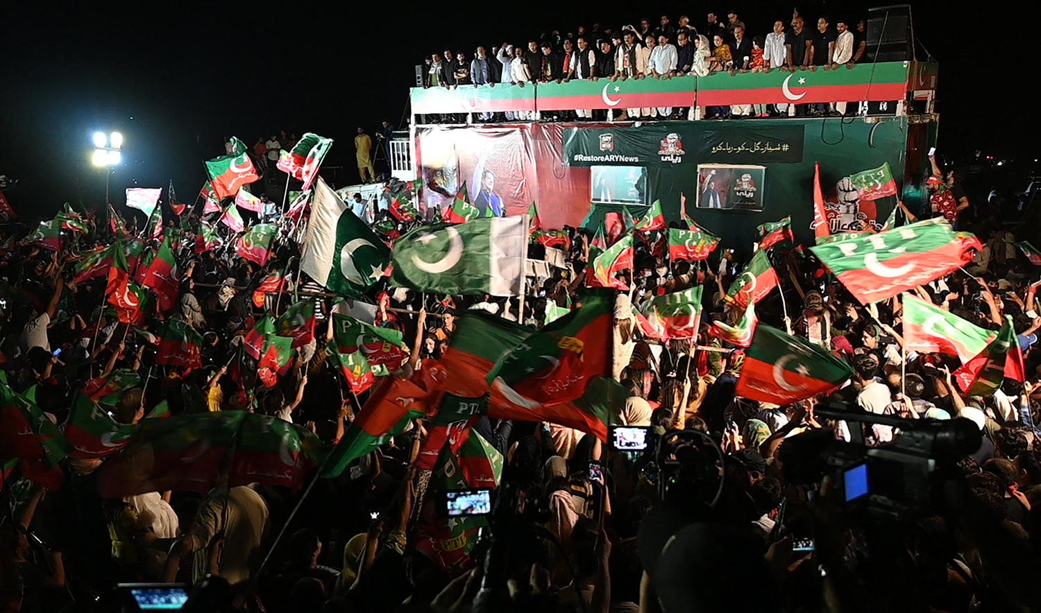 Supporters of Pakistan's former Prime Minister and leader of the Pakistan Tehreek-e-Insaf party (PTI) Imran Khan, wave flags during an anti-government protest rally in Islamabad on August 20, 2022. (AFP/File)