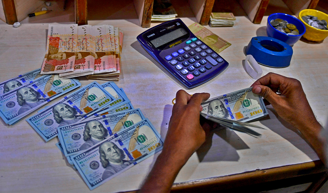 A foreign currency dealer counts US dollar notes at a currency market in Karachi, Pakistan, on July 19, 2022. (AFP/File)