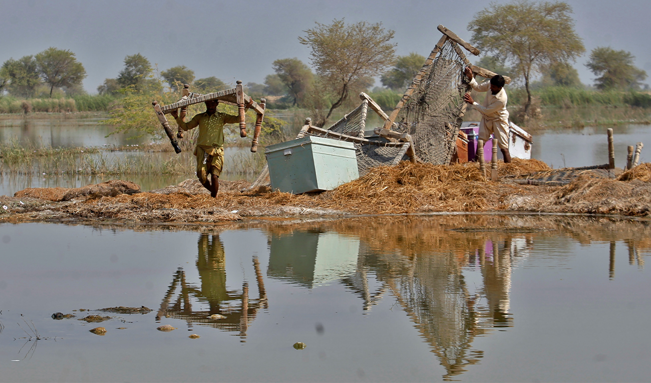 Villagers retrieve belongings they kept on the higher ground still surrounded by floodwaters in a village in Sohbat Pur, a flood-hit district of Balochistan province, Pakistan, onOctober 25, 2022. (AP)