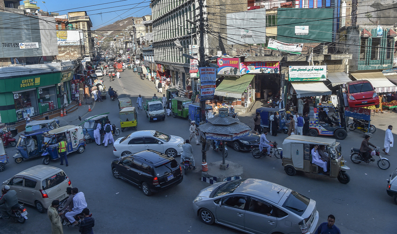 In this picture taken on October 25, 2022, commuters make their way along a busy road in a market area of Mingora, in the Swat District of Khyber Pakhtunkhwa. (AFP)