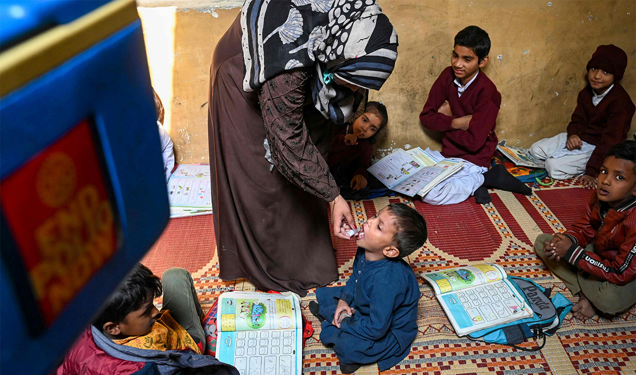 A health worker administers polio vaccine drops to a child at a school during a vaccination campaign in Lahore, Pakistan, on November 28, 2022. (AP)