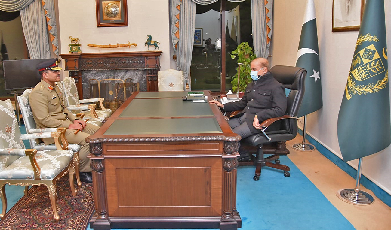 This handout picture taken and released by Pakistan Prime Minister's Office on November 24, 2022, shows Pakistan's Prime Minister Shehbaz Sharif (R) meets with the newly appointed army Chief General Syed Asim Munir (L) at the Prime Minister House in Islamabad. (AFP)