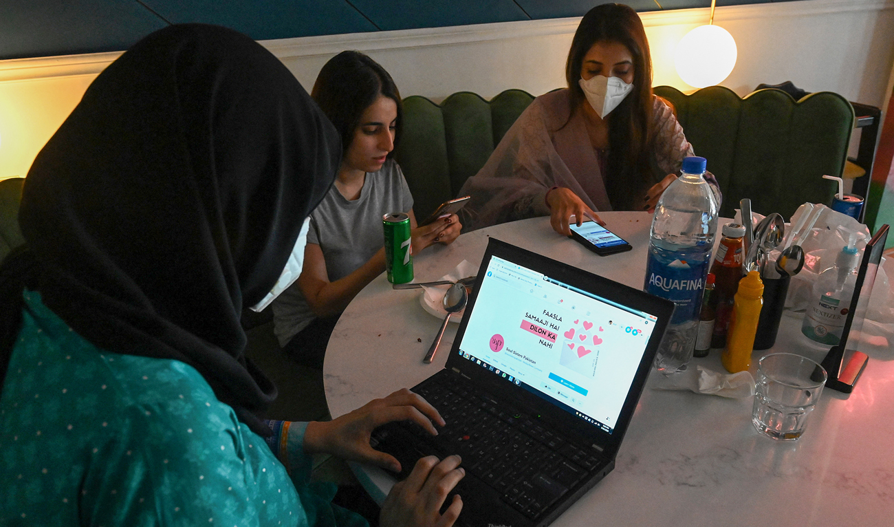 In this picture taken on August 31, 2020, women discuss as they check out the social online group in Lahore. (Photo courtesy: AFP/File)