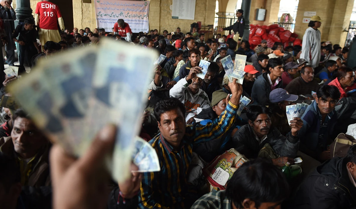 People hold up Pakistani currency at the railway station in Karachi January 5, 2017. (AFP/File)
