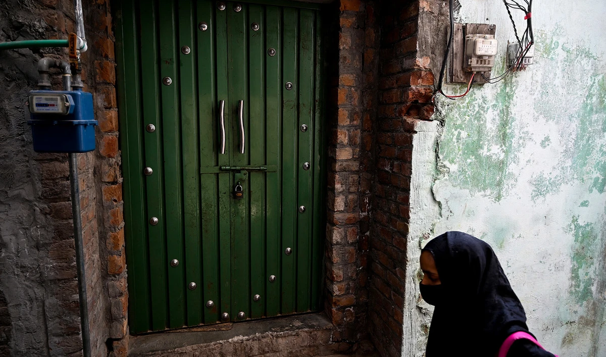 A child walks past a locked house of an attacker, who made an assassination attempt on former Pakistani prime minister Imran Khan, on his container truck a day after at Sodhra in Gujranwala district on November 4, 2022. (Photo courtesy: AFP)
