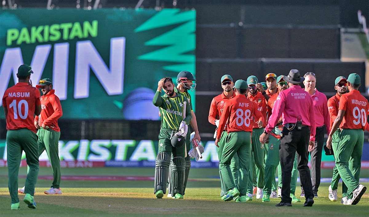 Pakistan's Shan Masood and Shadab Khan (C) walk off the field after their win during the ICC men's Twenty20 World Cup 2022 cricket match between Pakistan and Bangladesh at Adelaide Oval on November 6, 2022 in Adelaide. (AFP)