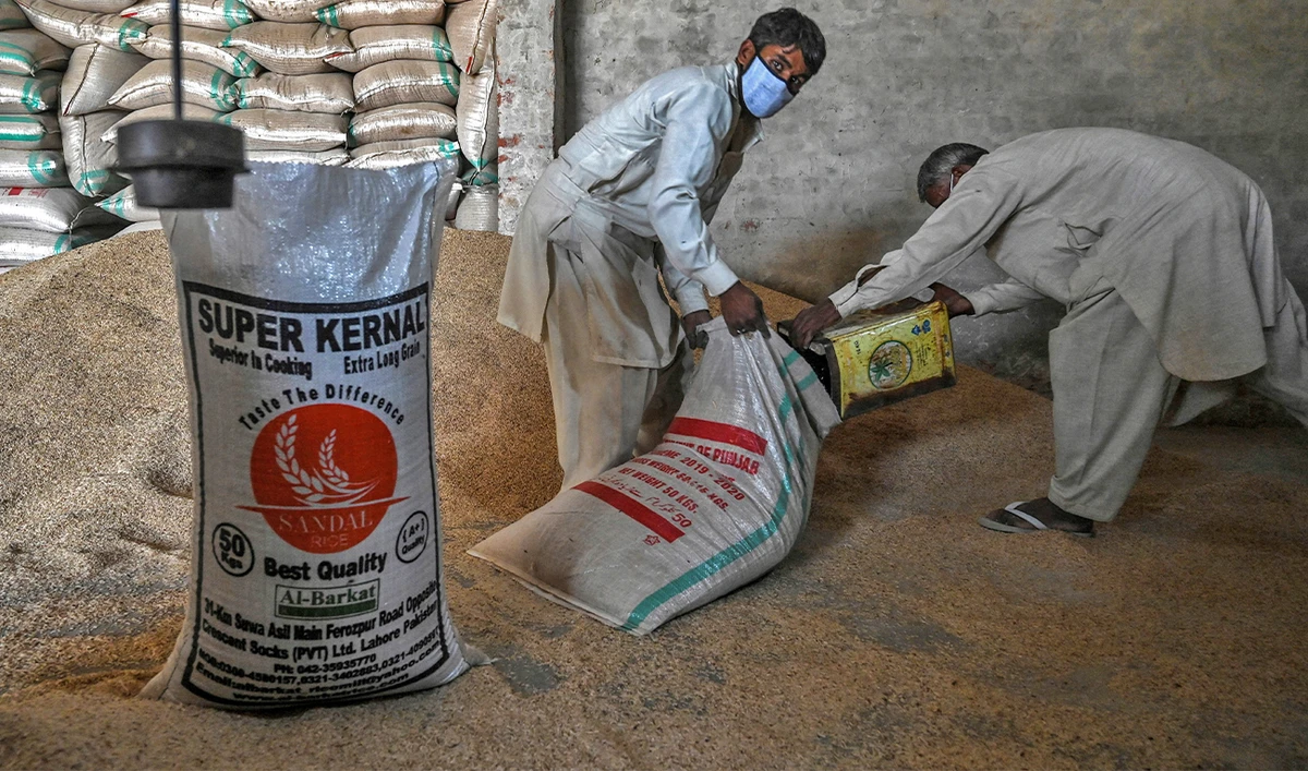In this picture taken on March 31, 2021 workers fill a sack with rice at the Al-Barkat Rice Mills on the outskirts of Lahore. (AFP/File)