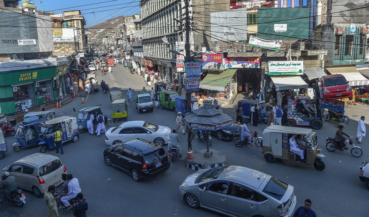 In this picture taken on October 25, 2022, commuters make their way along a busy road in a market area of Mingora, in the Swat District of Khyber Pakhtunkhwa. (AFP)