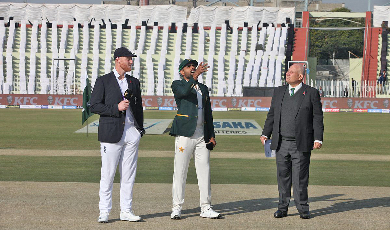 Pakistan skipper Babar Azam (second left) flips the coin for a toss and England's captain Ben Stokes (left) looks on before first Test cricket match between both countries at Rawalpindi Cricket Stadium in Rawalpindi, Pakistan, on December 1, 2022. (@PCB/Twitter)