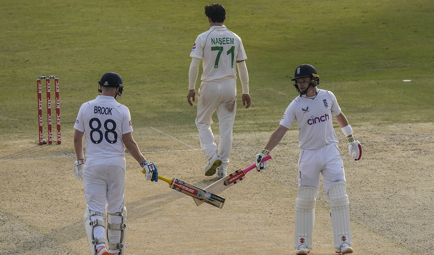 England's Ollie Pope, right, celebrates with teammate Harry Brook, left, after hitting a boundary during the first day of the first test cricket match between Pakistan and England, in Rawalpindi, Pakistan on December 1, 2022. (AP)