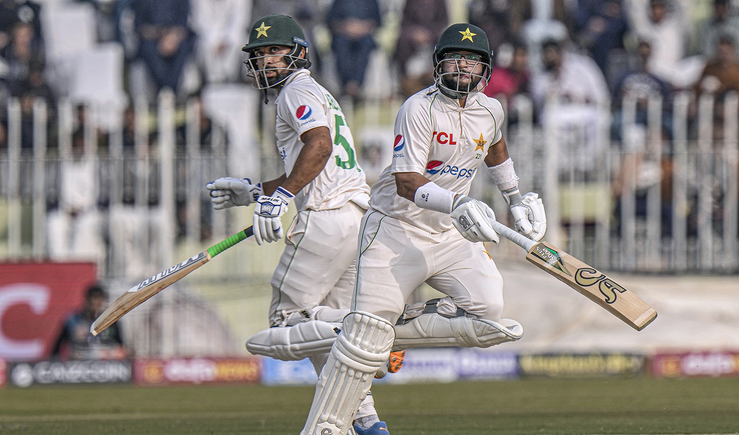 Pakistan's Imam-ul-Haq, right, and Abdullah Shafique run between the wickets during the second day of the first test cricket match between Pakistan and England, in Rawalpindi, Pakistan, on December 2, 2022. (AP)