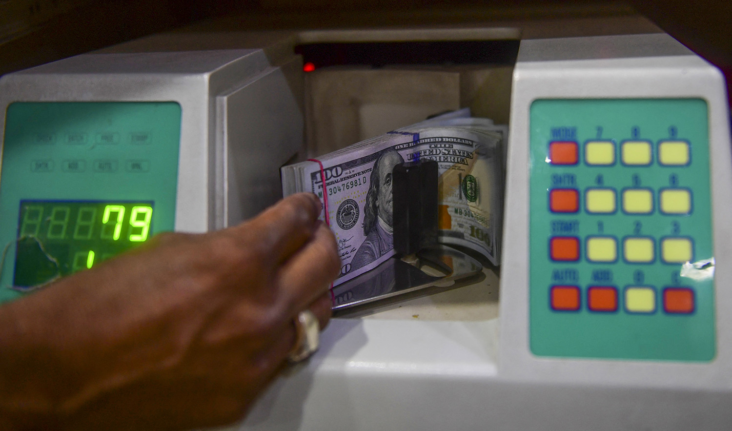 A foreign currency dealer counts US dollars at a shop in Karachi, Pakistan, on May 19, 2022. (AFP/File)
