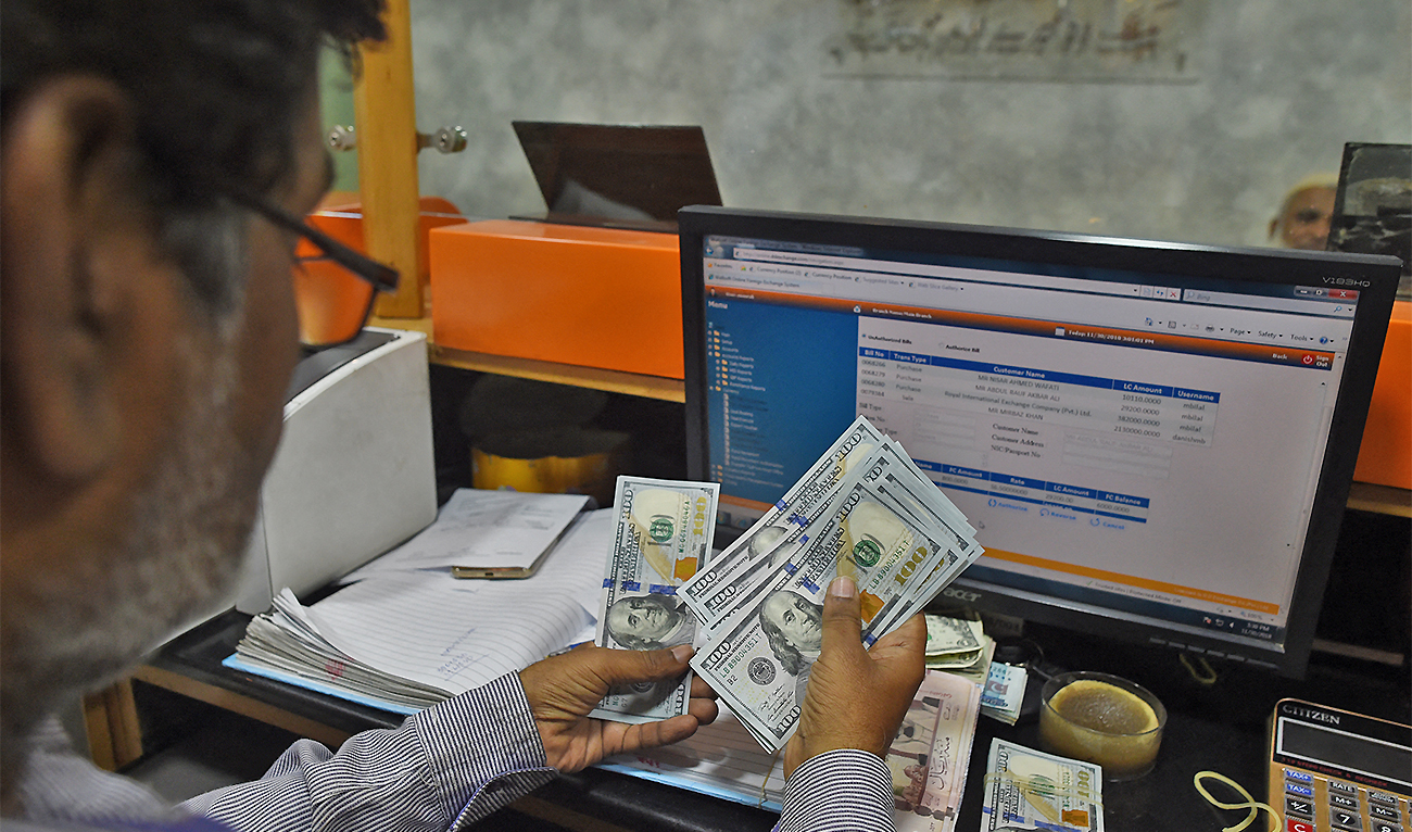 A Pakistani dealer counts US dollars at a currency exchange shop in Karachi, Pakistan, on November 30, 2018. (AFP/File)