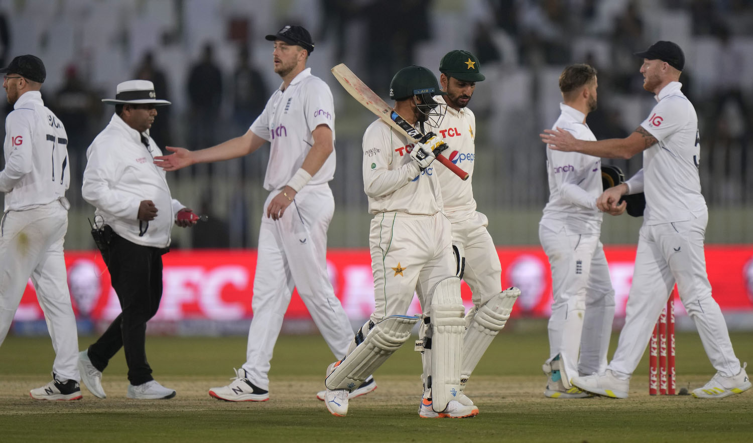 Pakistan's Zahid Mahmood, center, Salman Ali, third right, walk off the field as England's players shake hands on the end of the third day play of the first test cricket match between Pakistan and England, in Rawalpindi, Pakistan, on December 3, 2022. (AP)