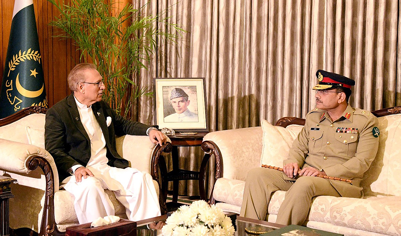 This handout photograph released by the Pakistan Press Information Department (PID) on November 24, 2022, shows Pakistan's President Arif Alvi (L) with incumbent army chief General Syed Asim Munir (R) at the President House in Islamabad. (Photo courtesy: AFP)