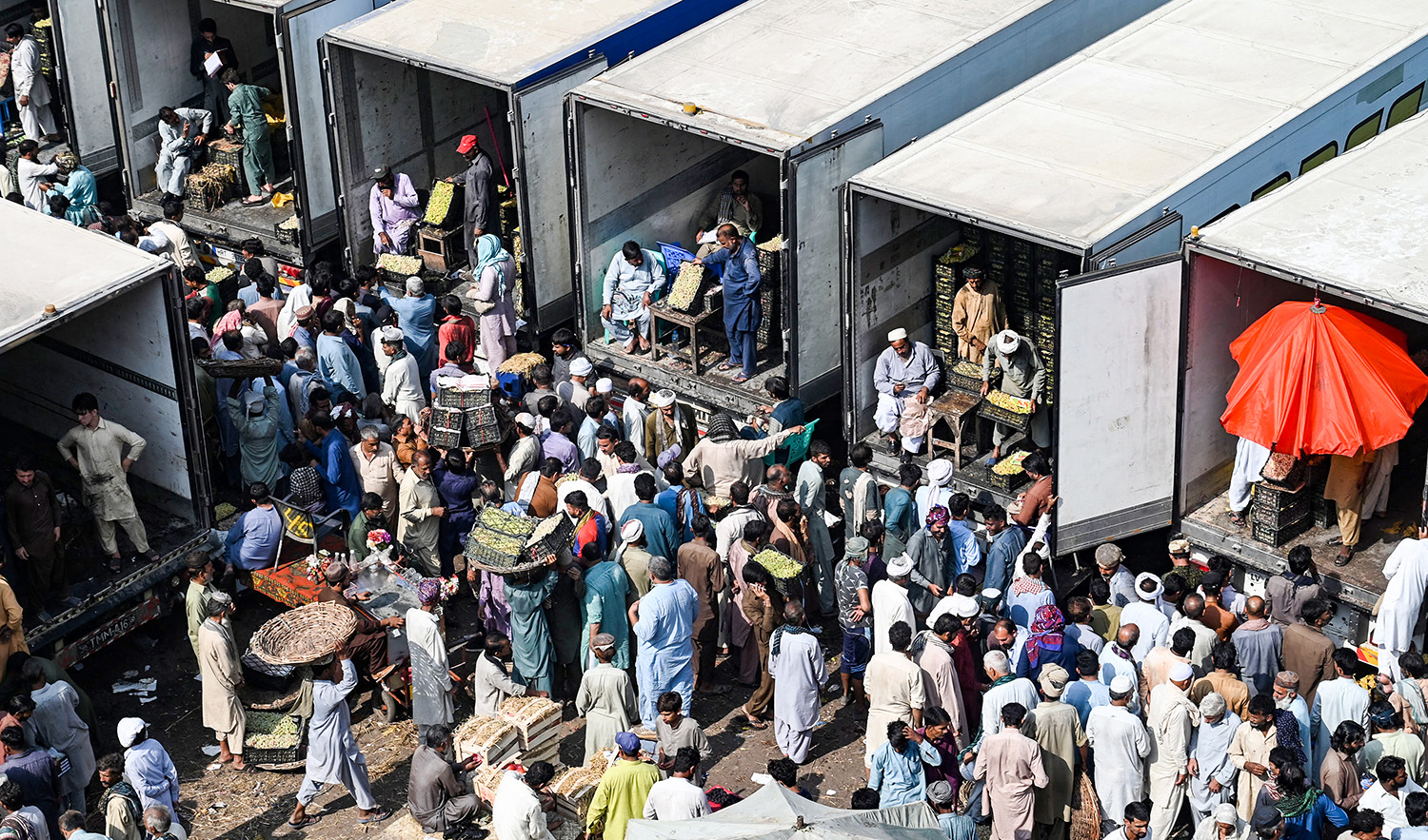 Traders, workers, and customers gather at a wholesale fruit market in Lahore on October 16, 2022, which also marks the ‘World food day.’ (AFP/File)