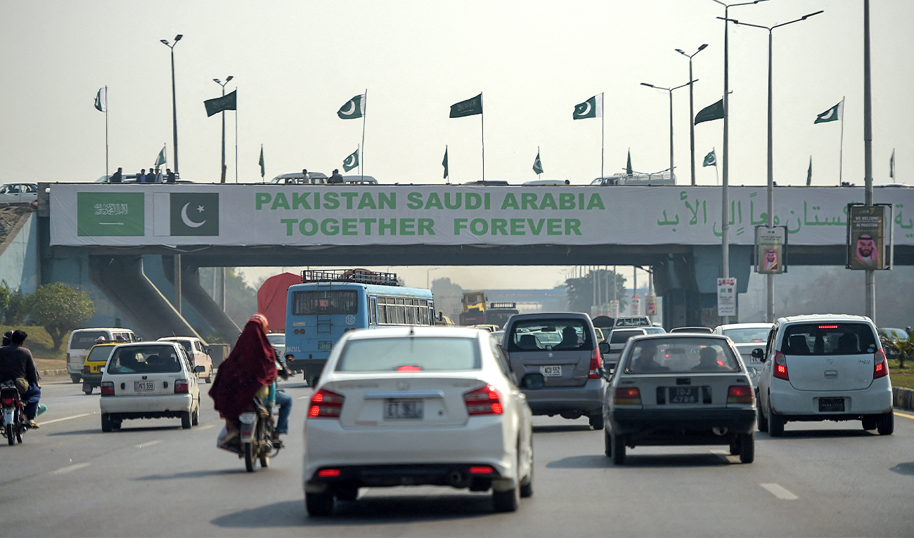 Pakistani commuters drive their vehicles under a banner welcoming Saudi Arabian Crown Prince Mohammed bin Salman displayed on a bridge, ahead of his arrival, in Islamabad, Pakistan, on February 15, 2019. (AFP/File)