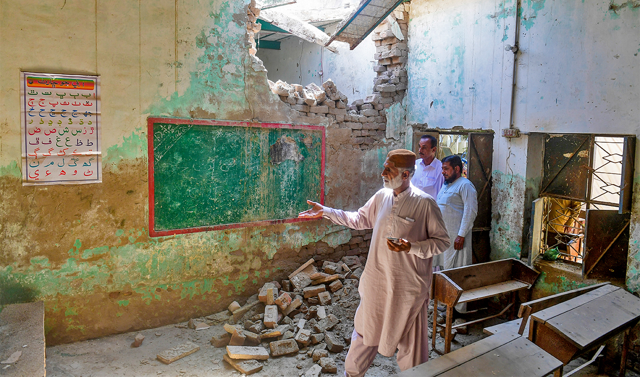 In this picture taken on October 28, 2022, a man shows a flood-affected classroom in Mounder town, in Dadu district of Pakistan's Sindh province. (AFP)