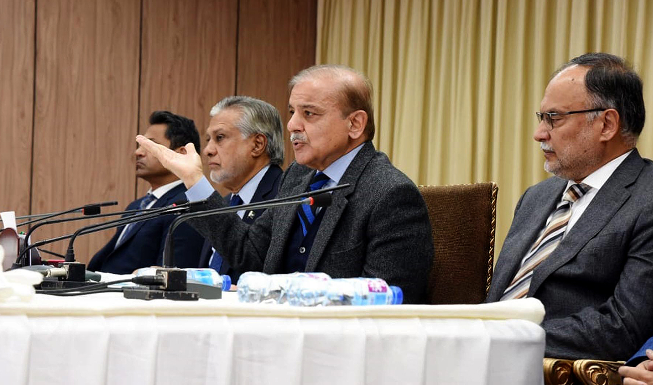 In this handout picture, released by Press Information Department, Pakistan Prime Minister Shehbaz Sharif (center) gestures during a press conference at Prime Minister's House in Islamabad on December 12, 2022. (Photo courtesy: PID)