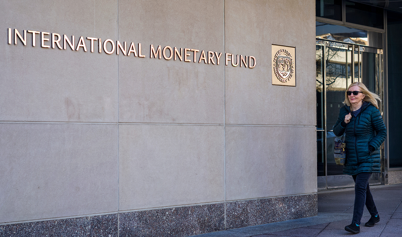 A woman walks past the International Monetary Fund (IMF) headquarters building in Washington, DC on March 11, 2022. (Photo courtesy: AFP/File)