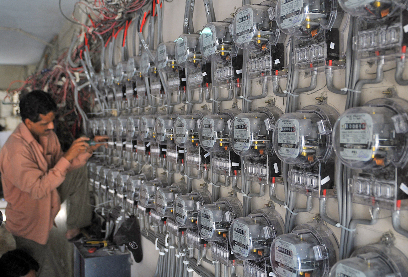 A technician fixes new electricity meters at a residential building in Karachi, Pakistan, on May 13, 2010. (AFP/File)