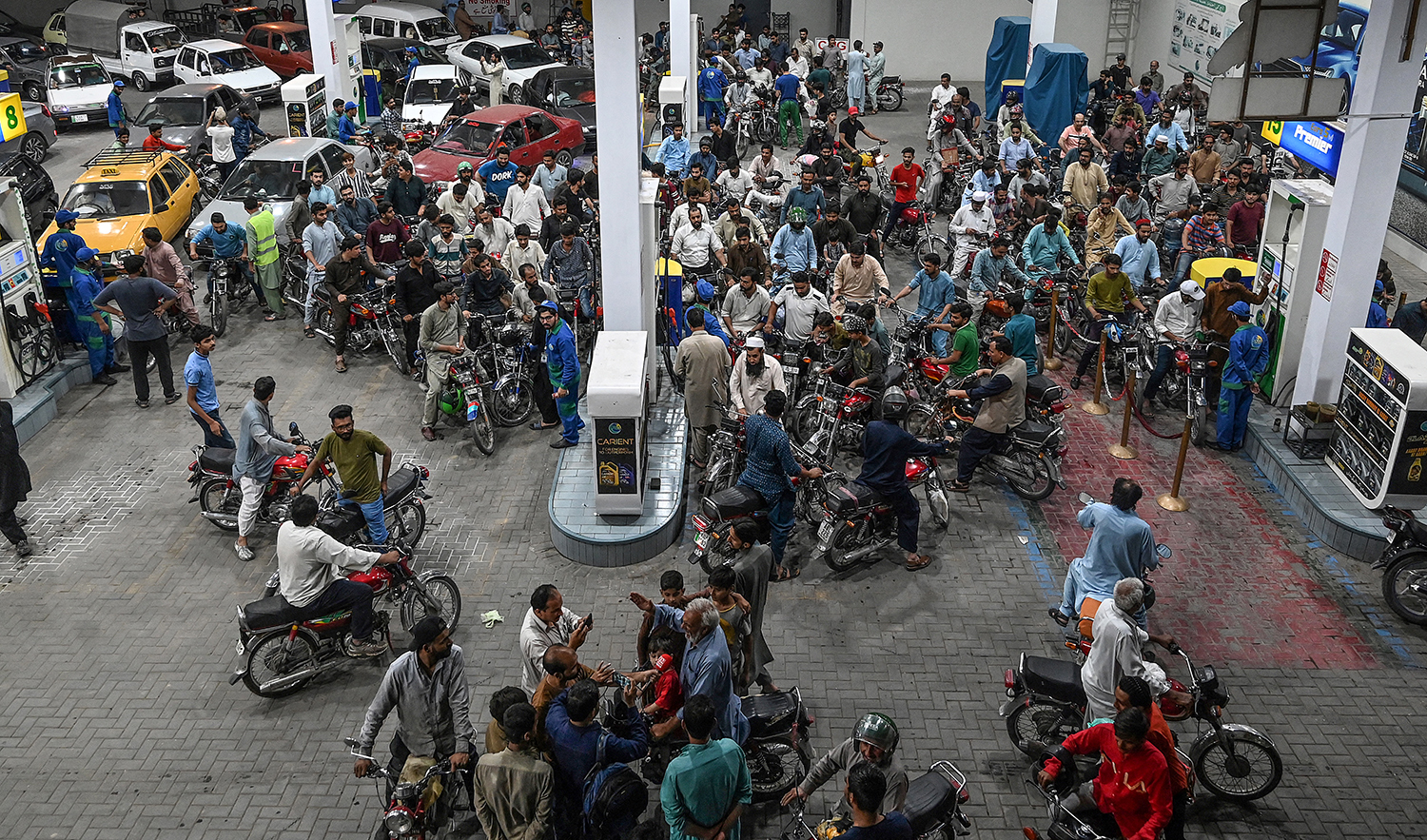 Motorists wait to fill their vehicles' tanks at a petrol station in Islamabad, Pakistan, on June 2, 2022, following an increase of petroleum prices by the government. (AFP/File)