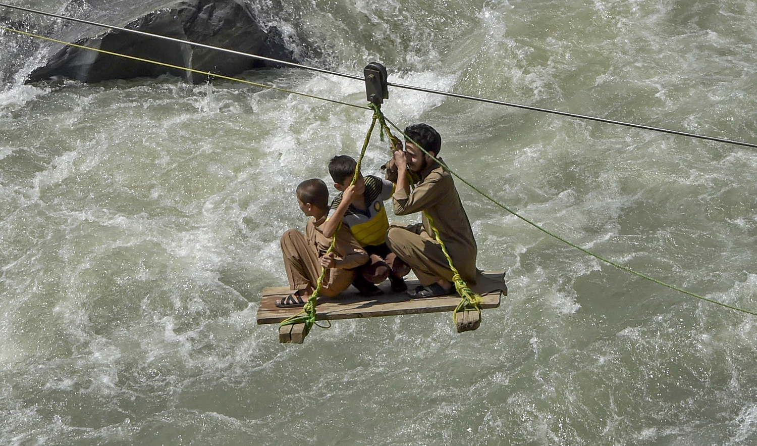 Local residents use a temporary cradle service to cross the river Swat after heavy rains in Bahrain town of Swat valley in Khyber Pakhtunkhwa province on August 31, 2022. (AFP/File)