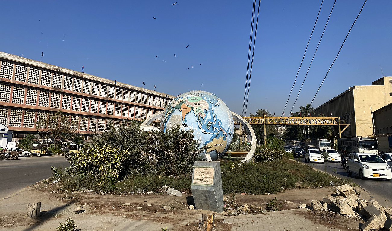 In this picture, taken on December 17, 2022, commuters pass by Karachi's iconic globe monument, situated at M.A. Jinnah Road in the Saddar area, which authorities plan to remove, making way for a mass transit project. (AN Photo)