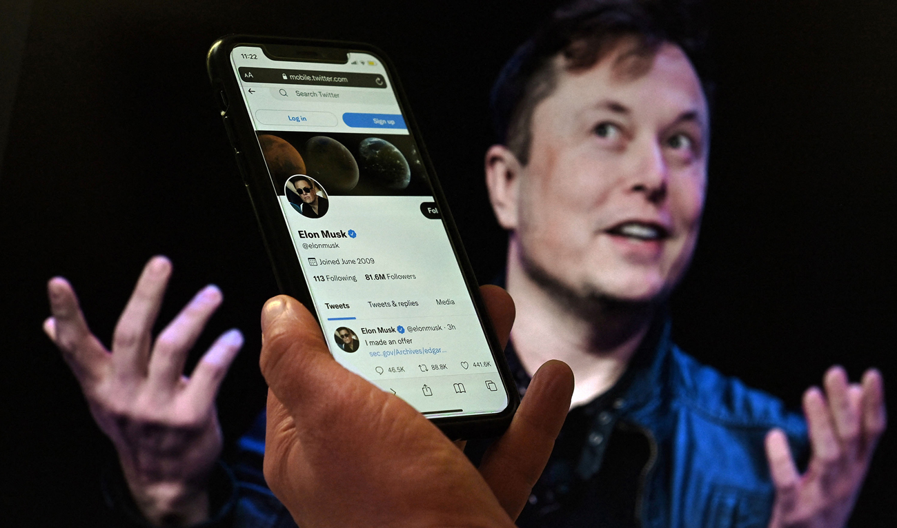 In this file photo taken on April 14, 2022 a phone screen displays the Twitter account of Elon Musk with a photo of him shown in the background, in Washington, DC. (Photo courtesy: AFP)