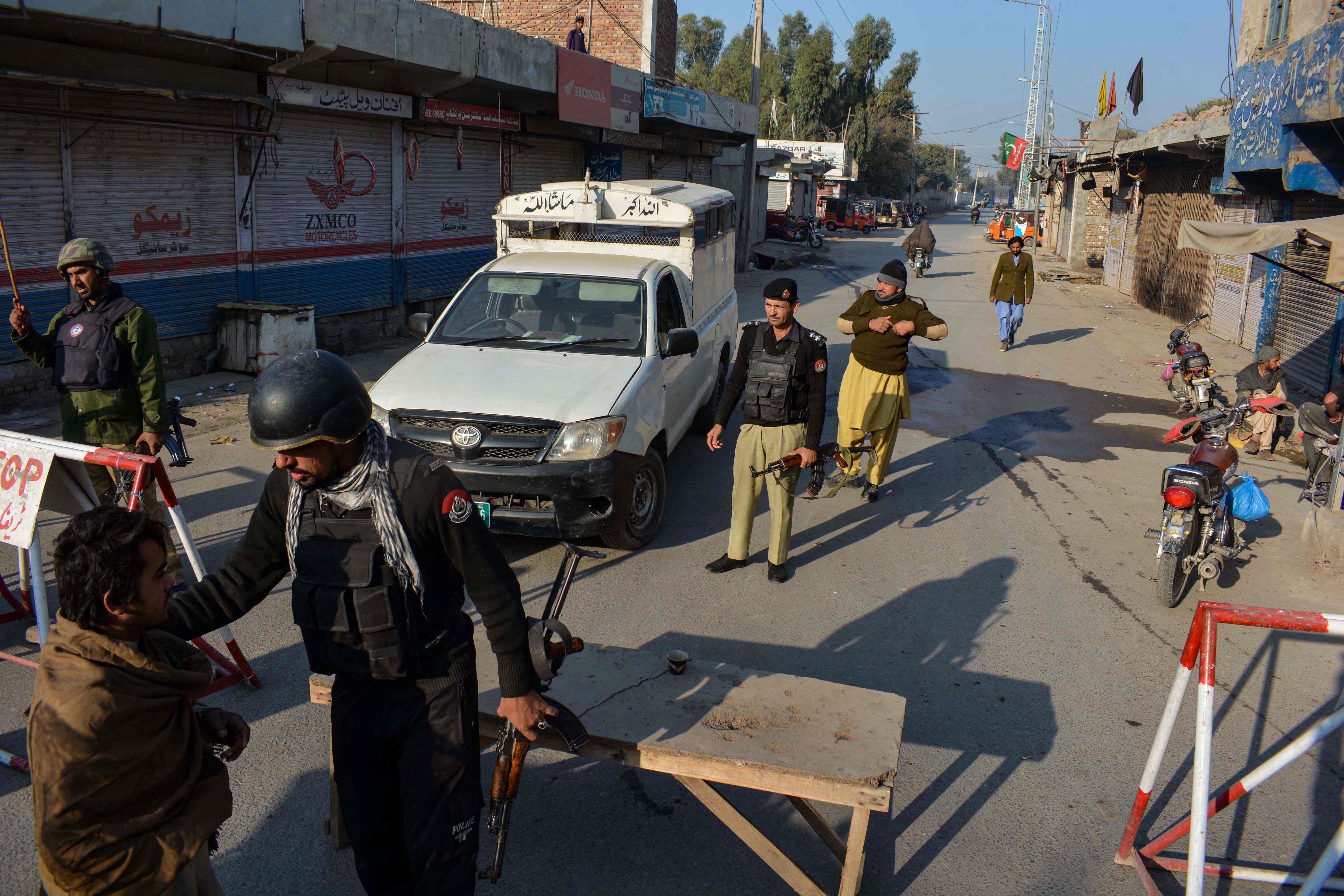 Police stand guard along a road they blocked after Taliban militants seized a police station in Bannu, Pakistan, on December 19, 2022. (AFP)